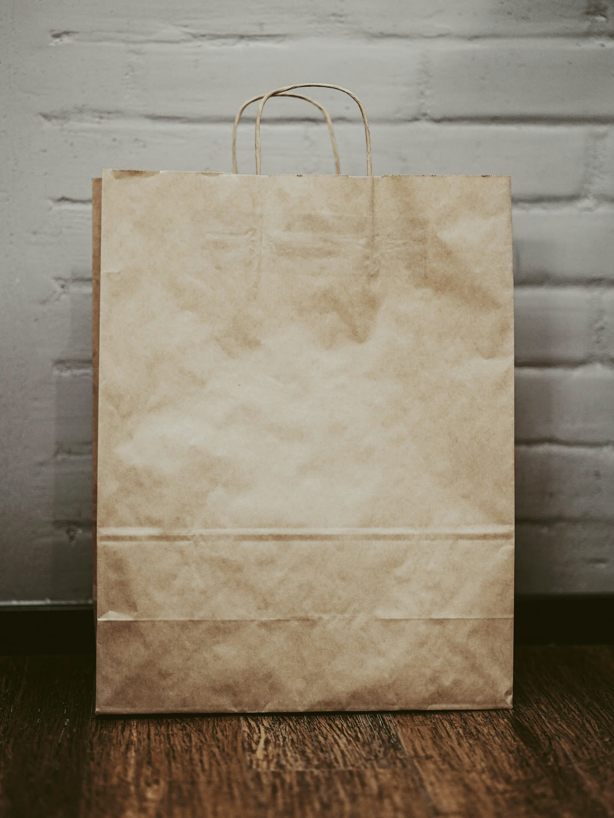 Una bolsa de papel madera de mostrador, cerrada, con el logo de GoodBite estampado